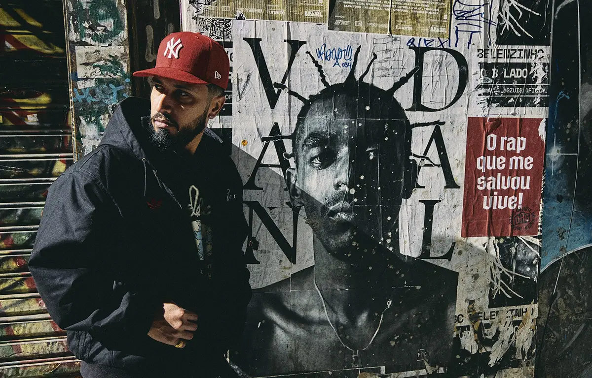 Rashid durante divulgação do álbum CUMULONIMBUS, com foto ao lado de mural de Sabotage