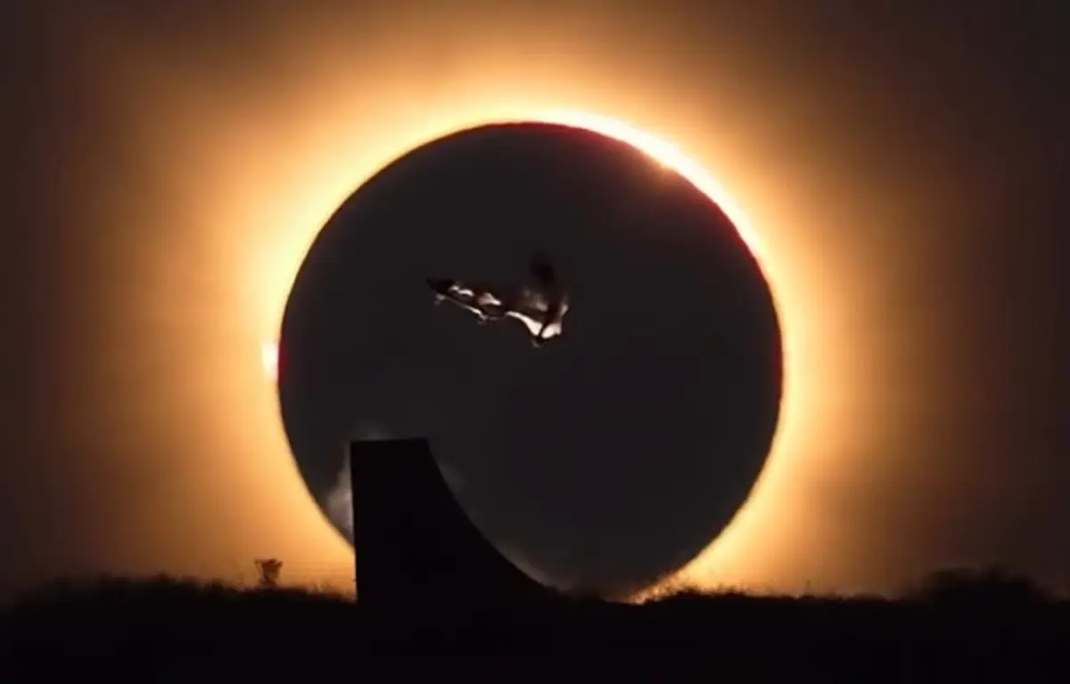 Danny León realizando manobra de skate diante do eclipse solar total